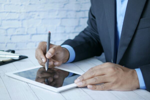 A person signs a legal document with a digital signature, which offers a higher level of security than standard electronic signatures.